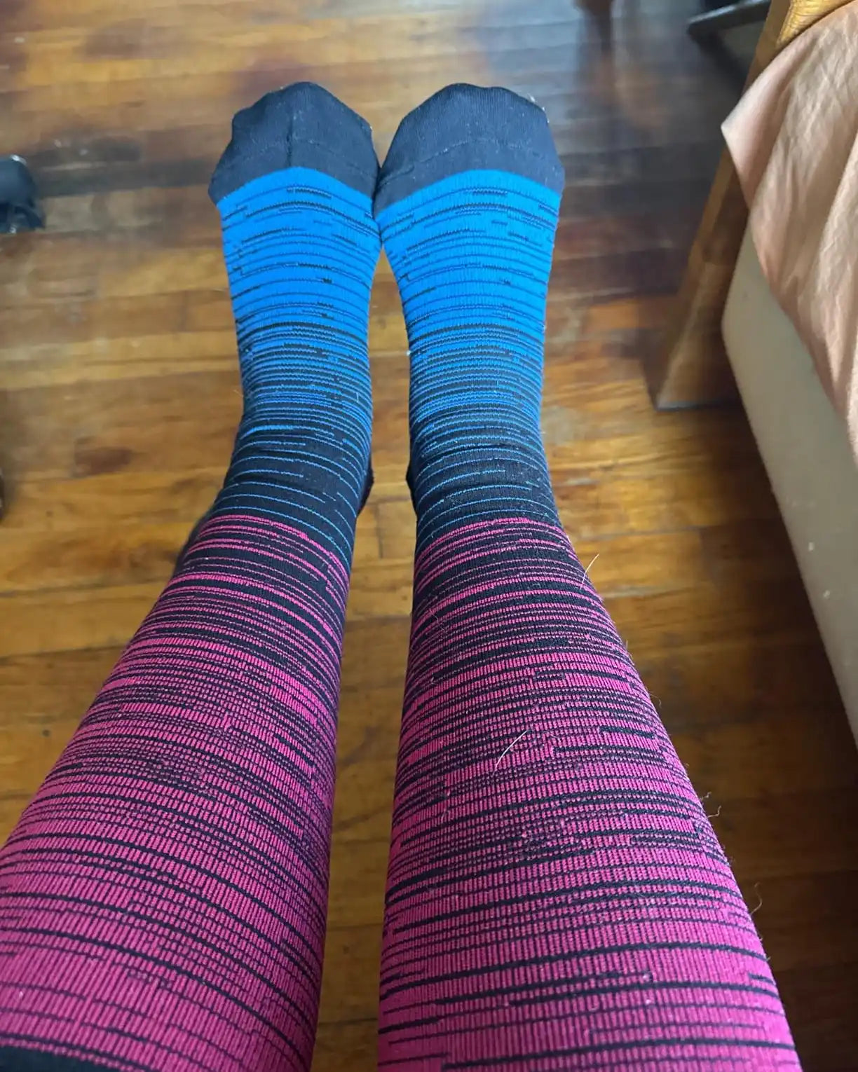 Chaussettes de compression rayées bleu et rose en dégradé.